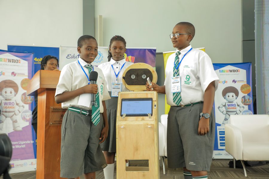 Students presenting their wooden robot on stage at the Uganda National Championship