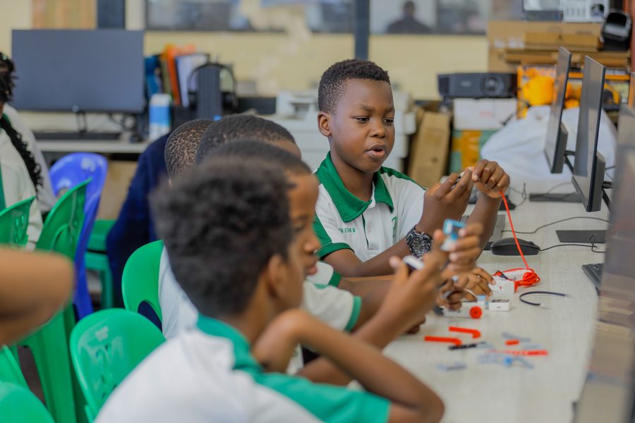 Pupils in school uniform wiring small electronic components